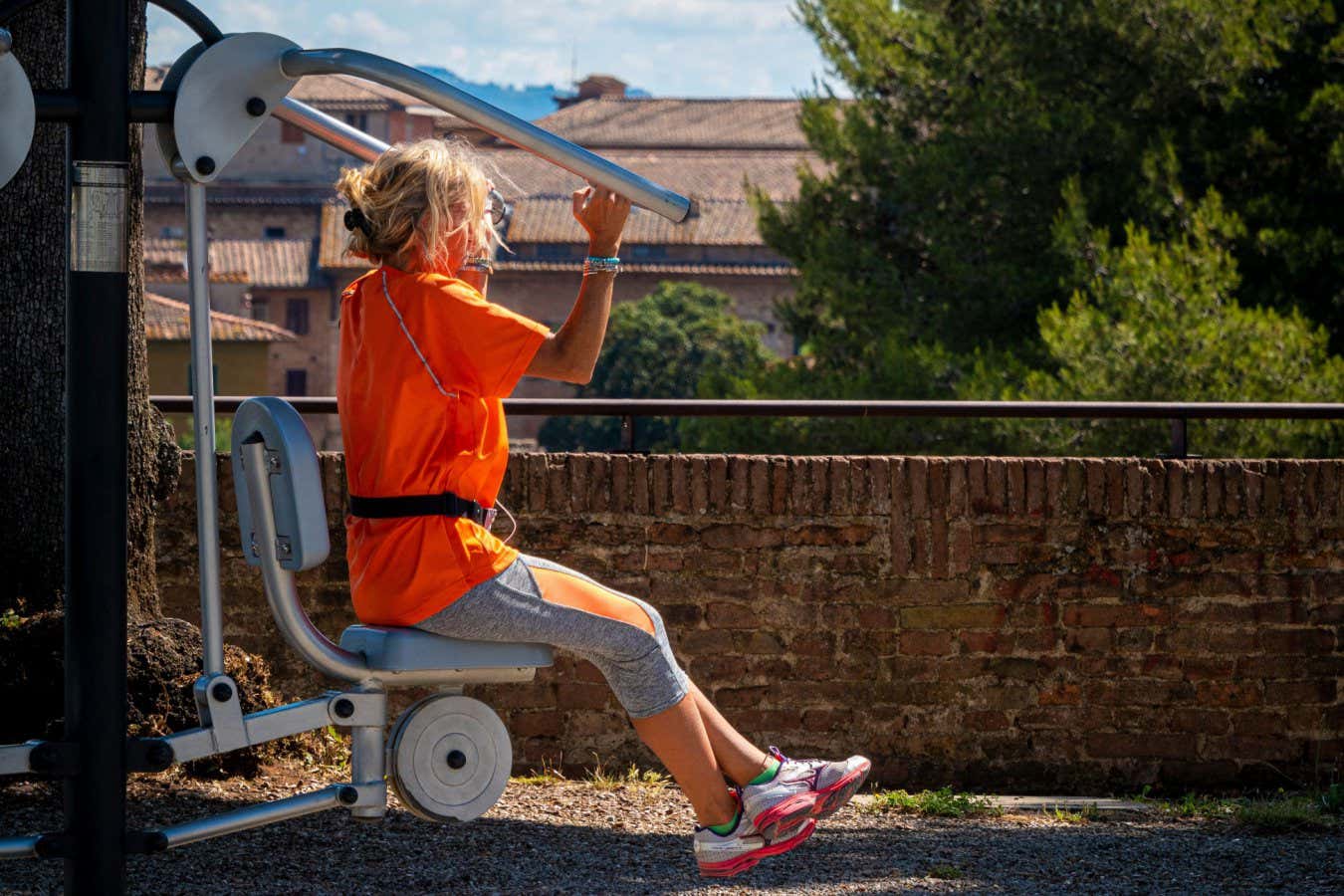 A woman uses outdoor gym equipment
