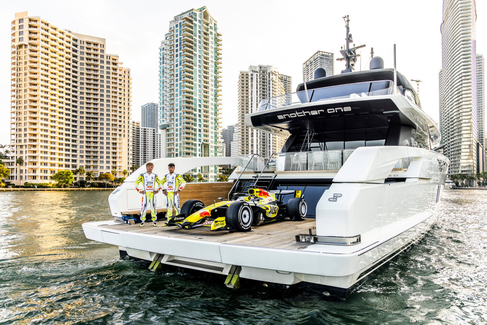 Arvid Lindblad and Liam Lawson on a boat with a Racing Bulls car
