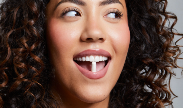 Woman with a UKLash suppplement in her mouth