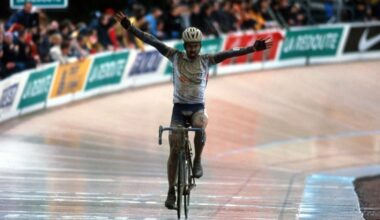 Servais Knaven crosses the line in the velodrome to win Paris-Roubaix 2001. It is clearly wet, he is covered in mud, and he has his arms out wide in celebration