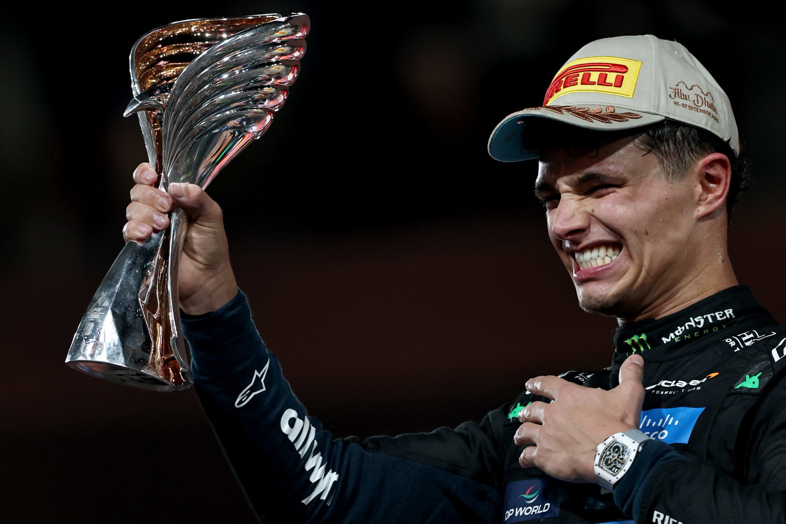 Lando Norris is happy with a trophy on the podium at Abu Dhabi after winning the F1 world championship