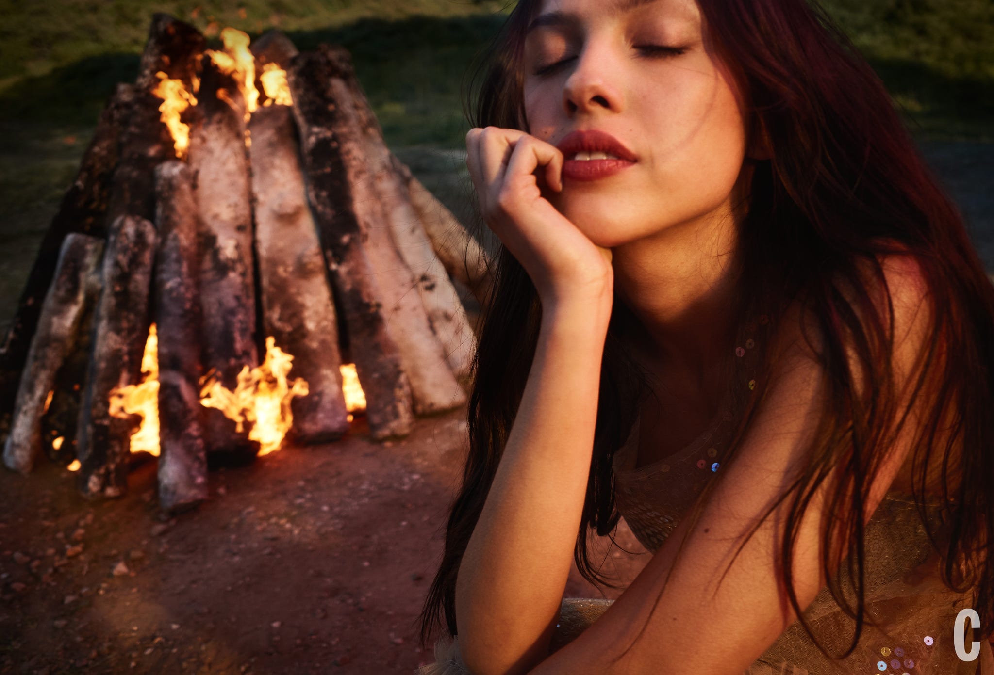 A person sitting near a bonfire. A person sitting near a bonfire.