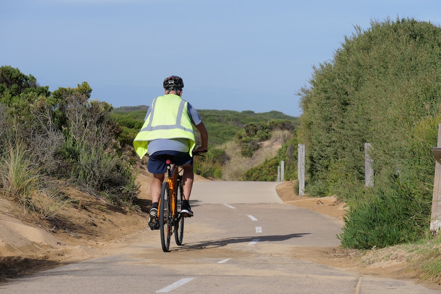 A person cycling along a beach path.