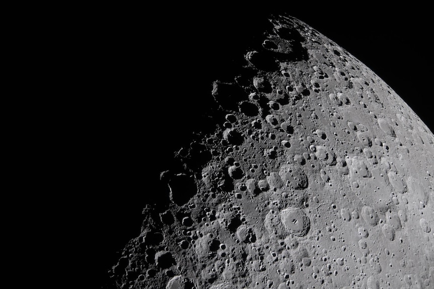 A close up of the moon. low-angle sunlight casts long, dramatic shadows across the surface.