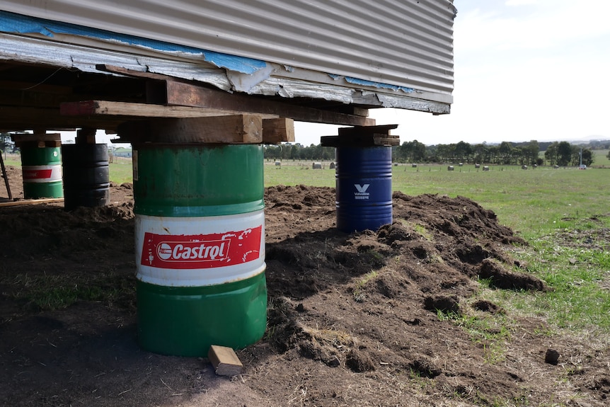 a home is stacked on oil drums for support