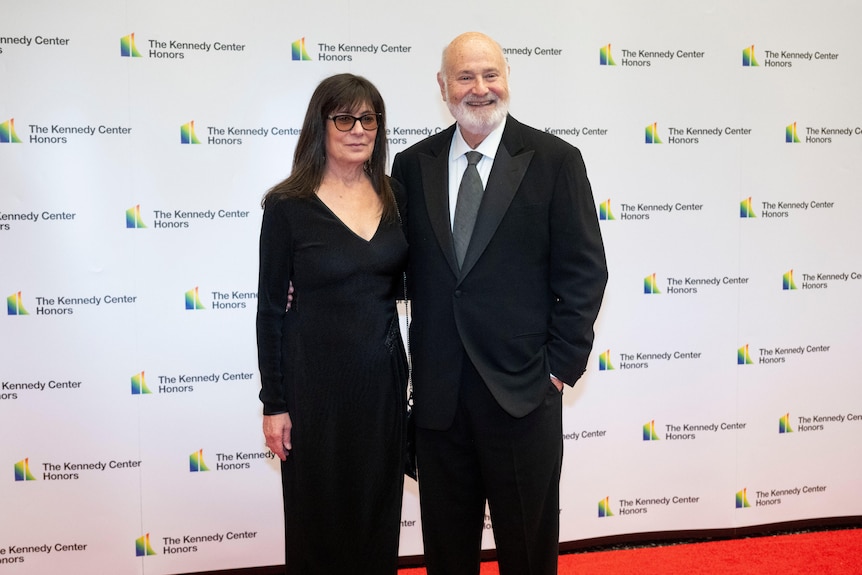 Rob Reiner and his wife Michele posing for a photo on a red carpet.