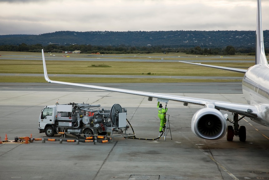 Person fuelling up plane