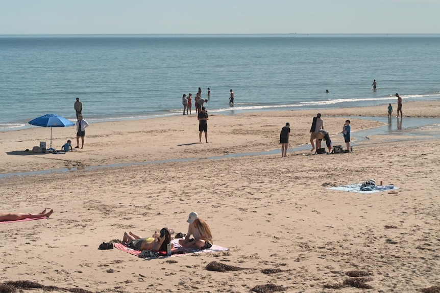 People walking and sitting on a beach