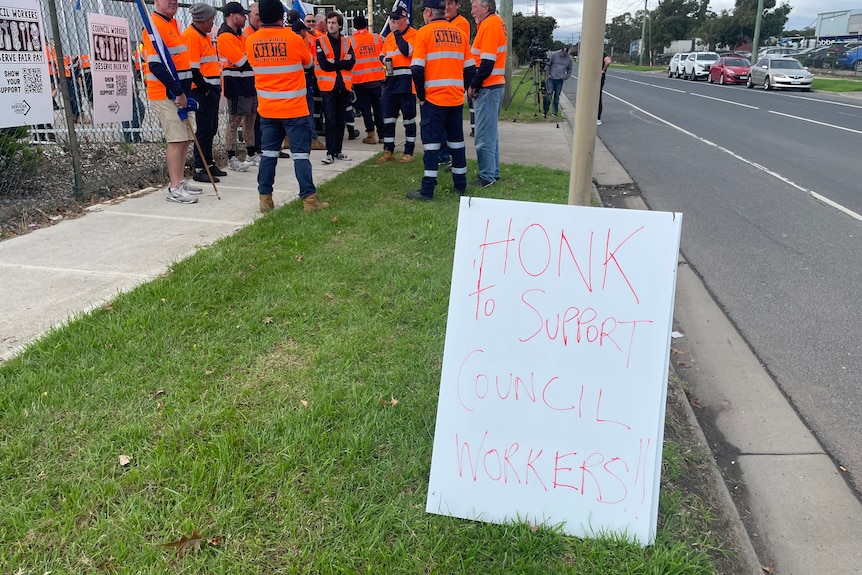 A sign saying honk to support council workers.