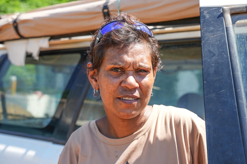 a woman with short hair looks sternly at the camera