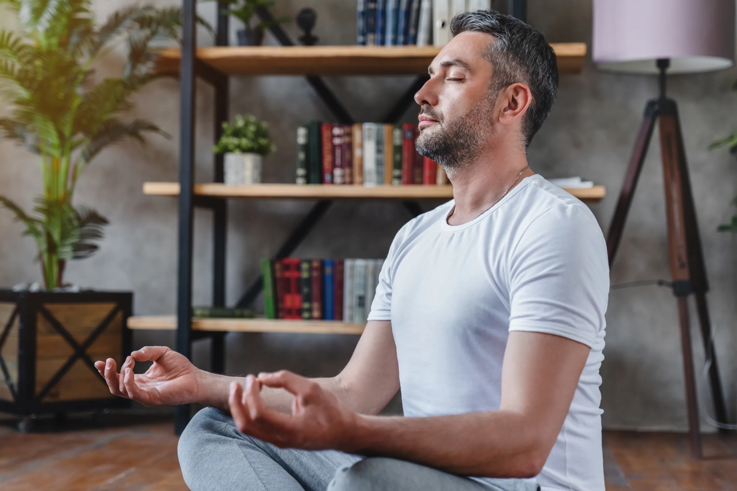 Middle-aged man meditating in his living room.