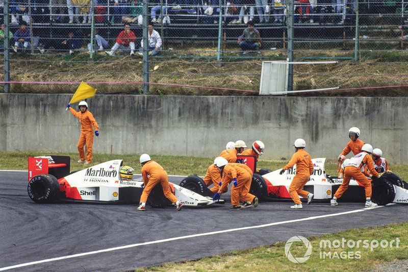 Prost jumps out of his McLaren, but Senna beckons the stewards to help him get going again