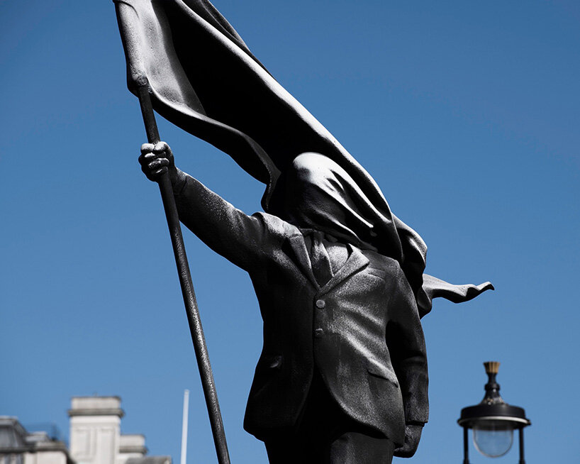anonymous flag-bearer by banksy walks among london's historic monuments - 4