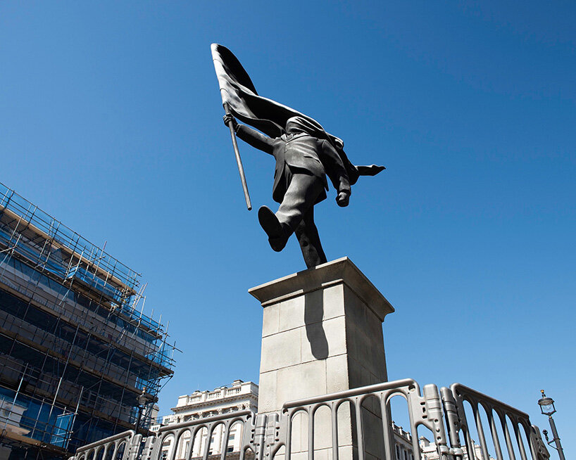 anonymous flag-bearer by banksy walks among london's historic monuments - 2