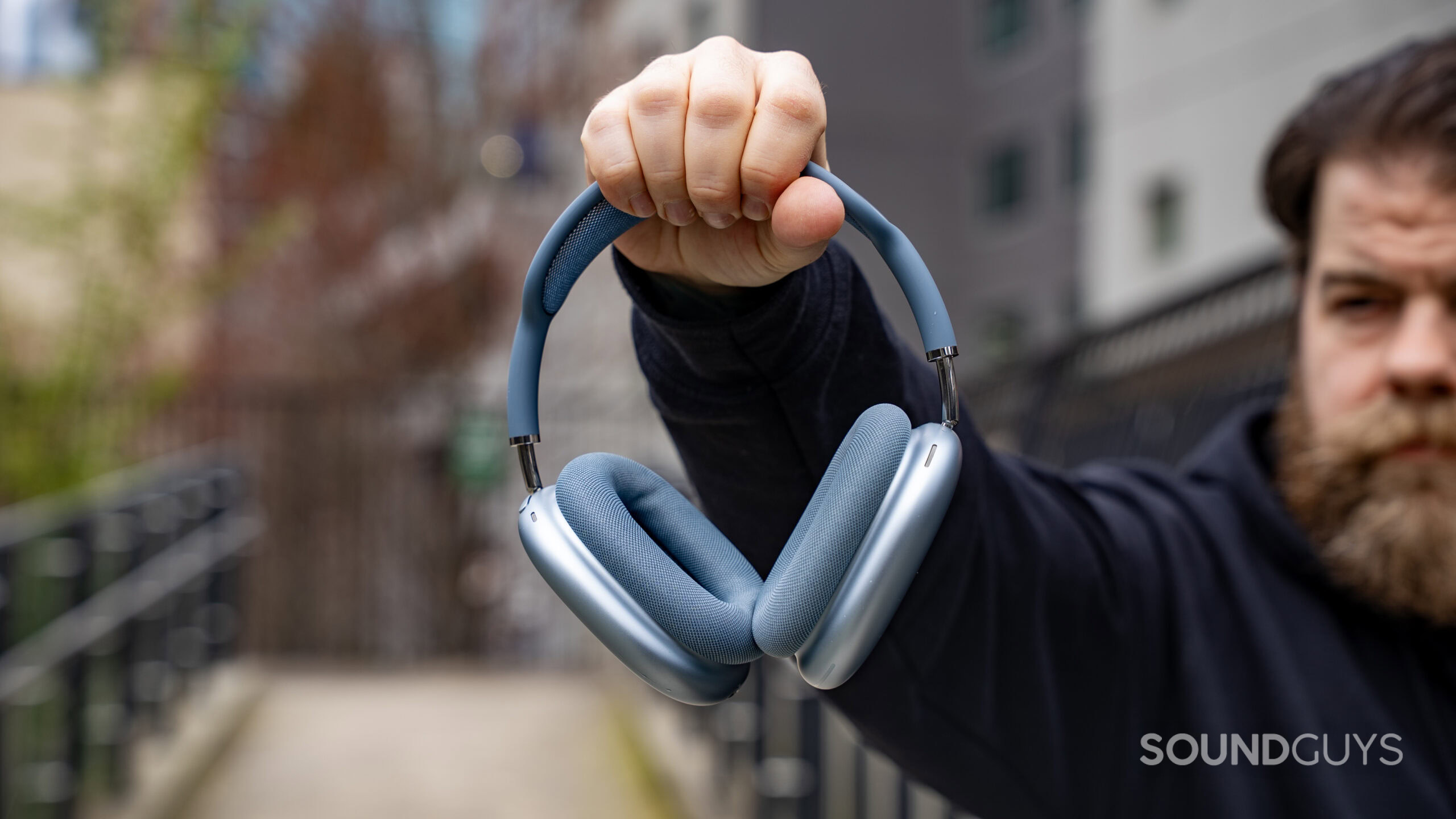 apple airpods max 2 held in hand Apple AirPods Max 2 headphones in a man's hand who is holding the headphones in the air