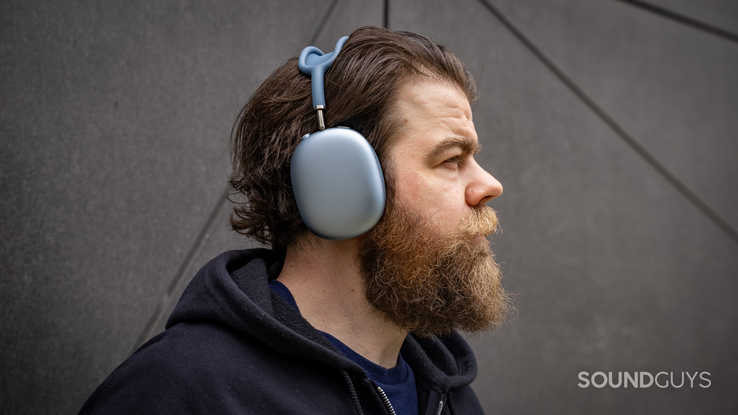 apple airpods max 2 man wearing right profile shot A man looks in the distance wearing the Apple AirPods Max 2 headphones