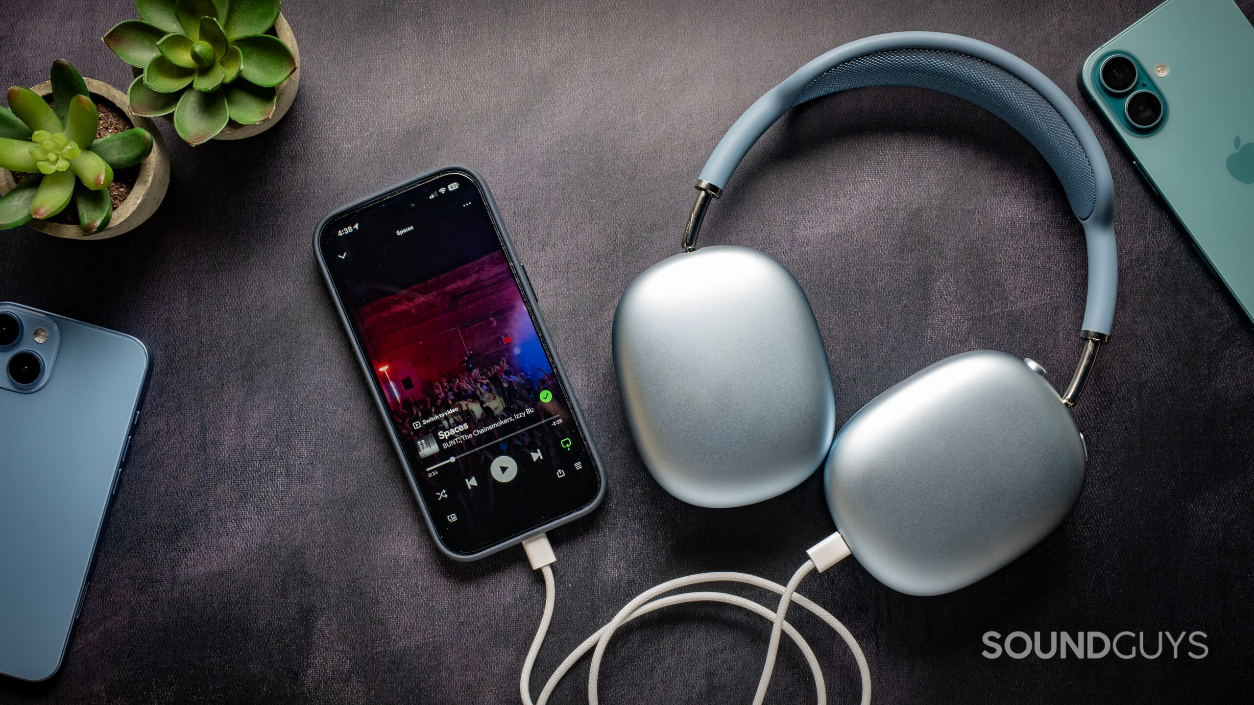 apple airpods max 2 usb-c listening audio Apple AirPods Max 2 headphones on a table plugged into an iPhone 17 Pro playing music on Spotify.