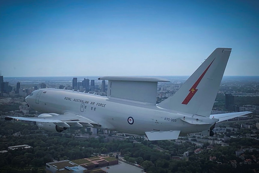 A plane flies over a city