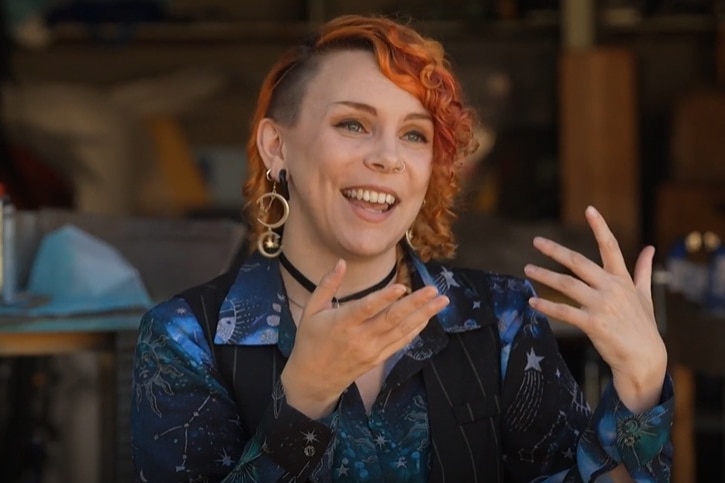 A woman gestures while speaking to the camera
