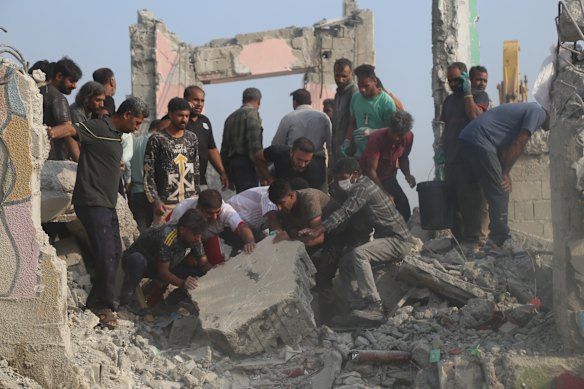 Rescue workers search through the rubble of the destroyed school in Minab, Iran, in February.