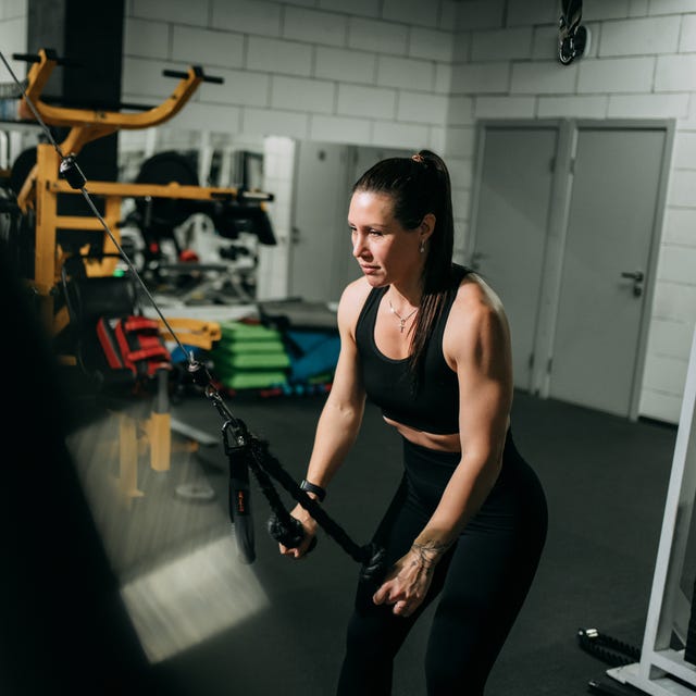 Woman training in gym with cable machine Woman training in gym with cable machine