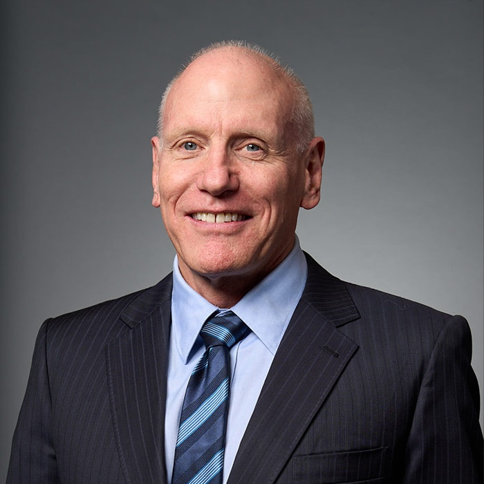 A bald man wearing a suit and tie