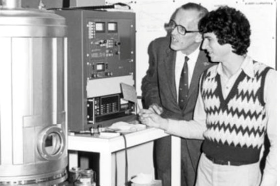 A black and white photo of two men in a lab.