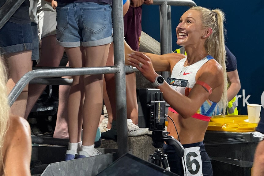 Runner Jess Hull smiles as she talks to fans