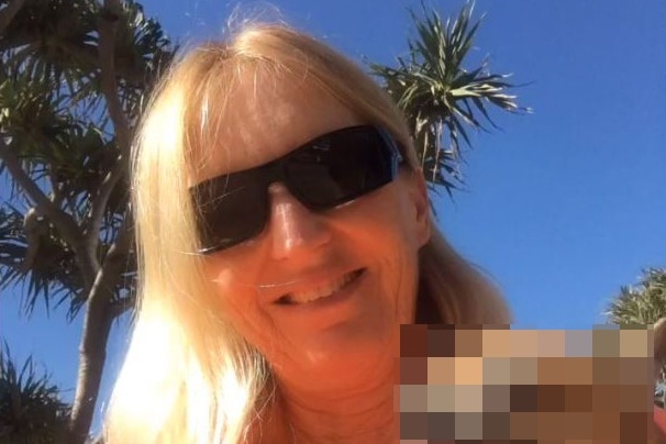 Maree Crabtree wearing sunglasses holding onto a small dog while outside.