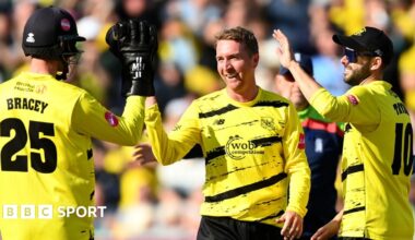 Tom Smith celebrates a wicket for Gloucestershire with team-mates