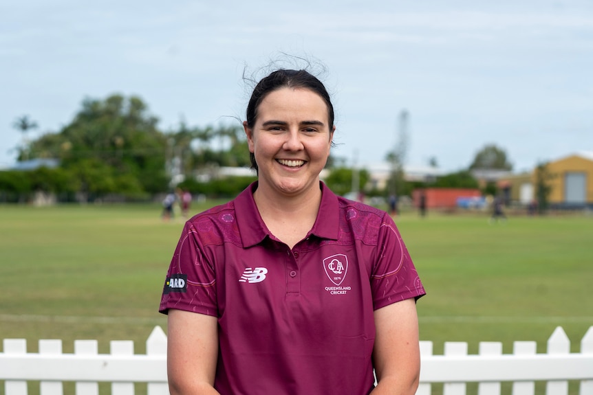 a woman smiling at the camera in cricket clothes