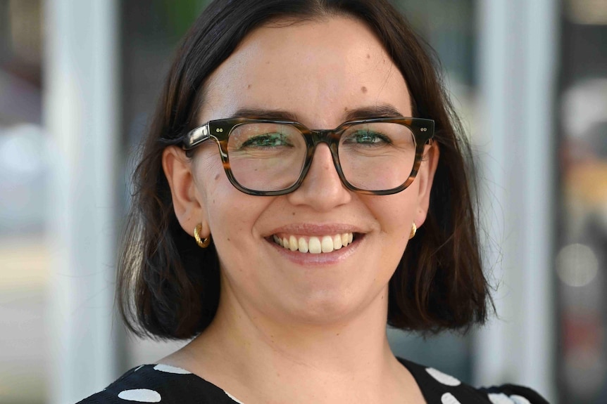 A woman with short black hair and glasses.