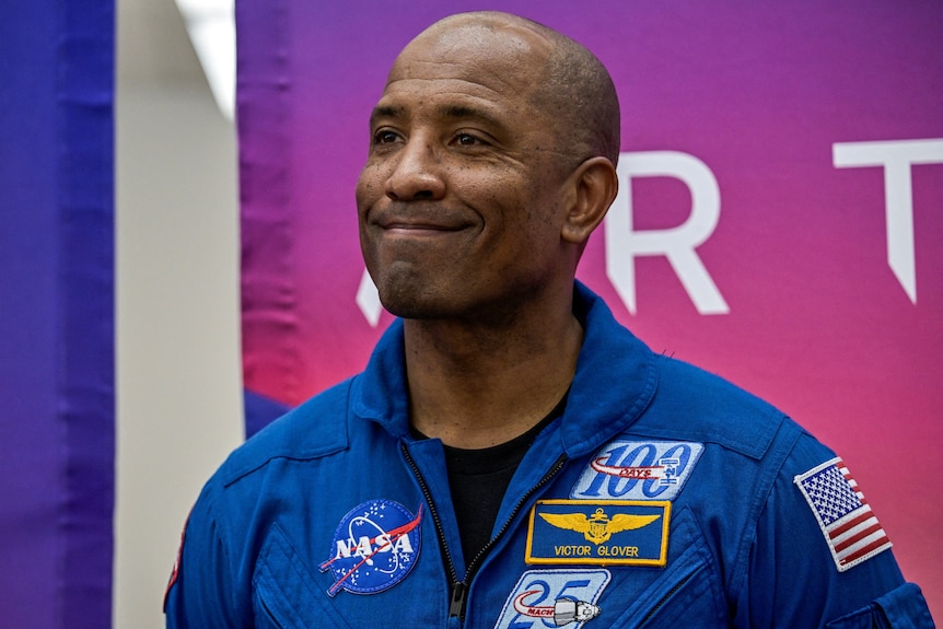 Astronaut Victor Glover smiling in his NASA suit