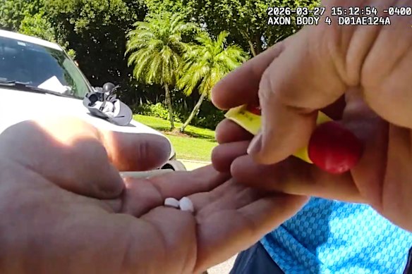 A sheriff’s deputy holds two pills after a search of Woods’ pants.