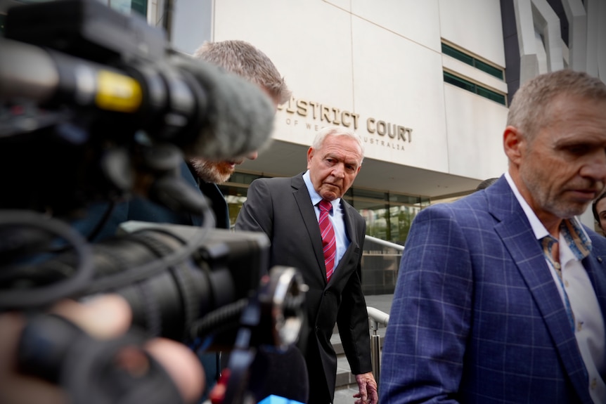 Barry Cable seen walking down stairs with a TV camera in the foreground.