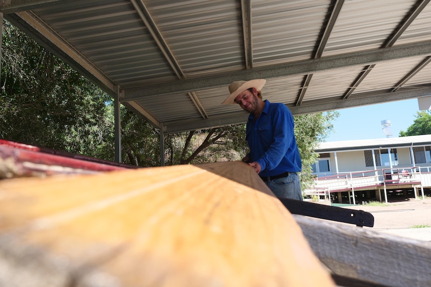 man inspects timber plank