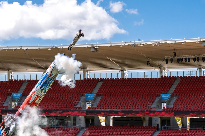 A man is shot out of a cannon in an arena.