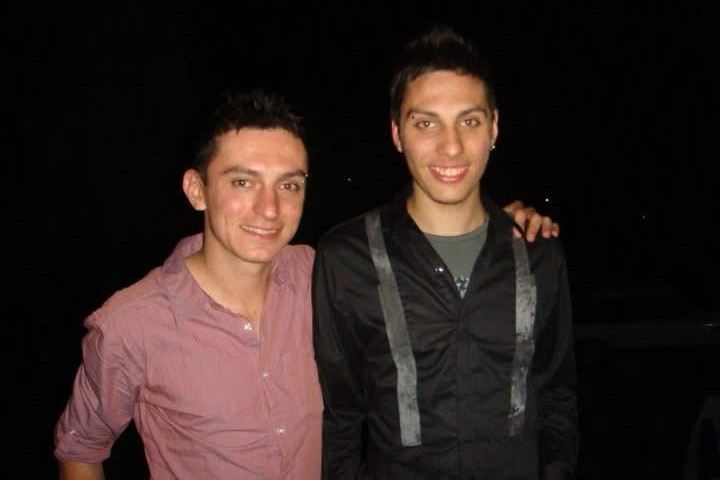 Two young First Nations men smile and pose for a photograph