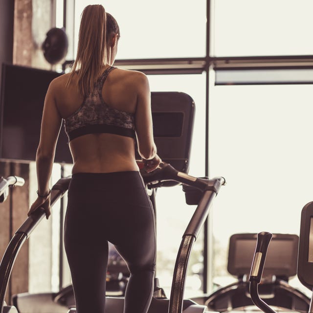 Full length of fit young female working out on stair climbing machine Full length of fit young female working out on stair climbing machine