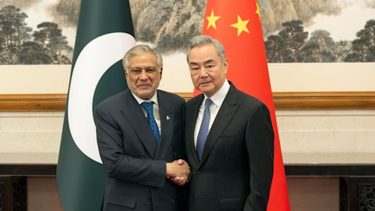 Chinese Foreign Minister Wang Yi, right, poses for photos with Pakistani Deputy Prime Minister and Foreign Minister Mohammad Ishaq Dar in Beijing.