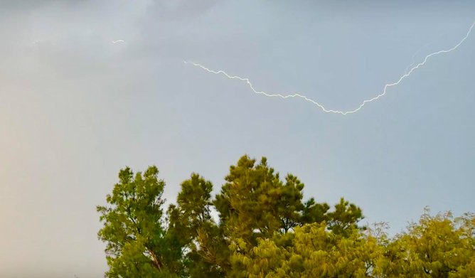 A lightning bolt streaks across the sky.