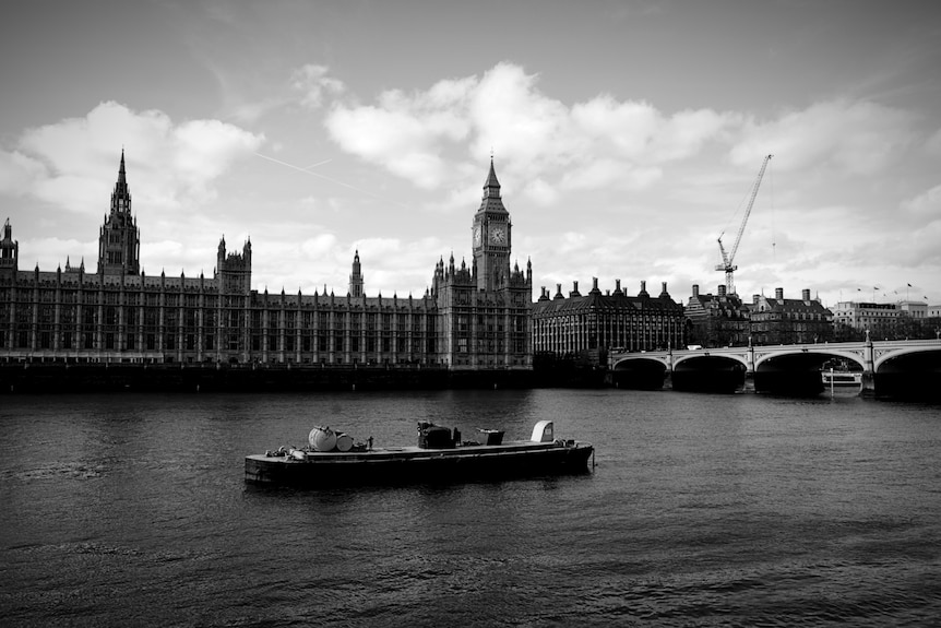Buses driving past the Houses of Parliament and Big Ben in London.