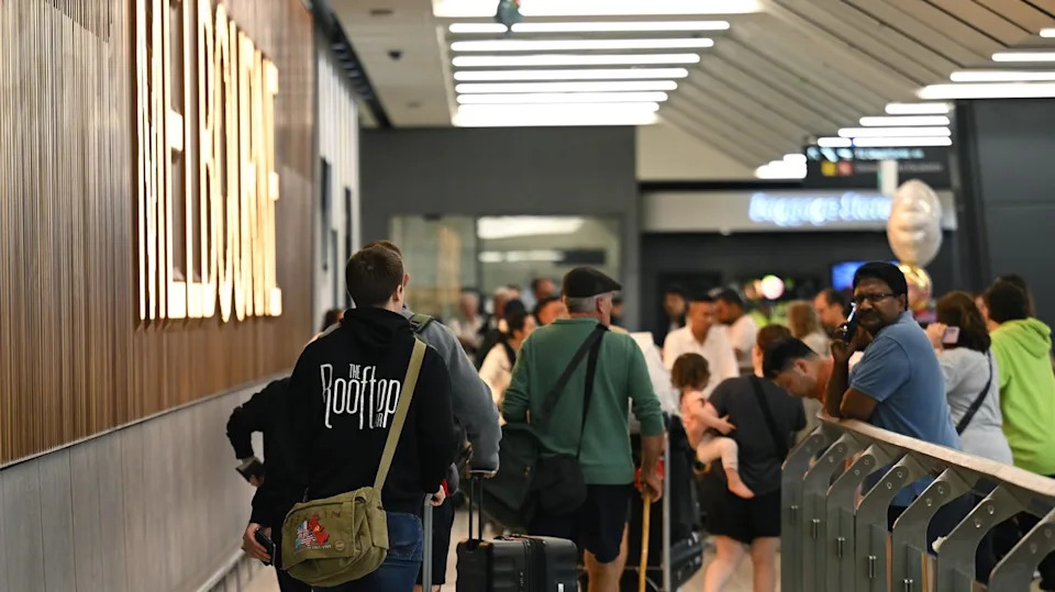 People arrive at the international arrivals gate at Melbourne