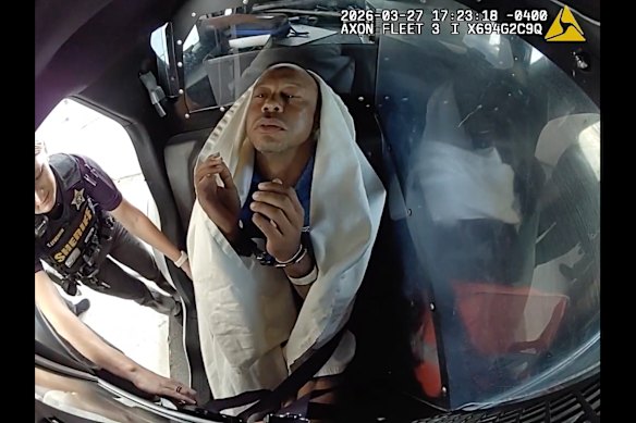 Woods strapped into a patrol car after his arrest.