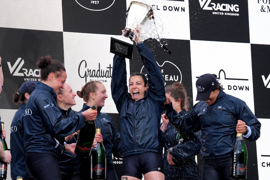 Oxford rowers celebrate with the trophy after winning the women's Boat Race.