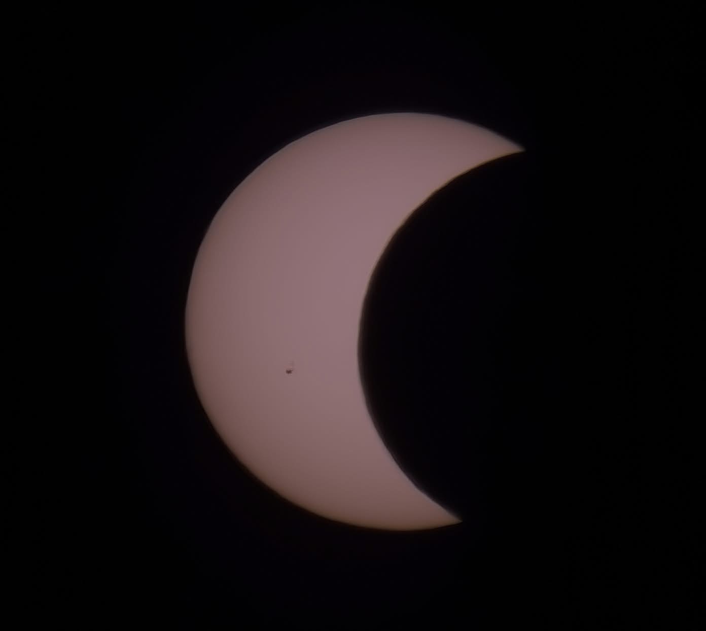 close up view of the sun appearing as a crescent as the moon starts to cover it.