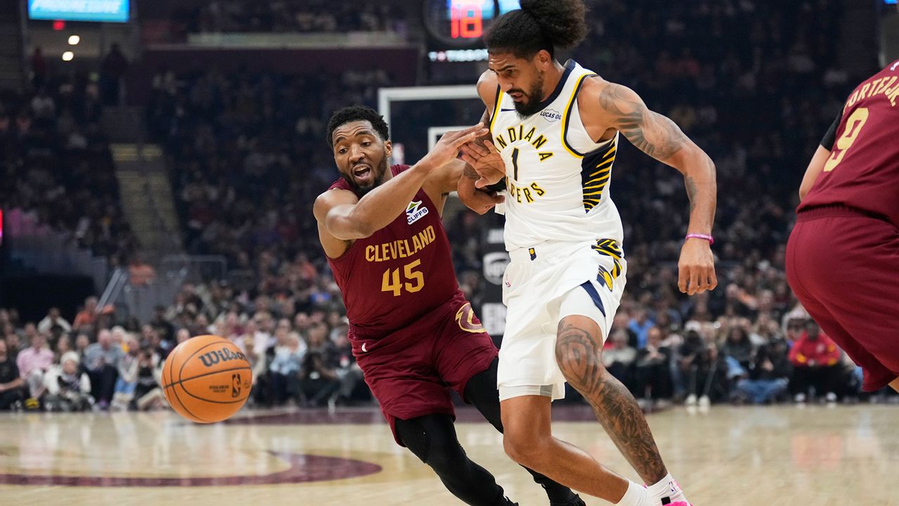 Cleveland Cavaliers guard Donovan Mitchell (45) knocks the ball away from Indiana Pacers forward Obi Toppin (1) in the first half of an NBA basketball game in Cleveland, Sunday, April 5, 2026. (AP Photo/Sue Ogrocki)