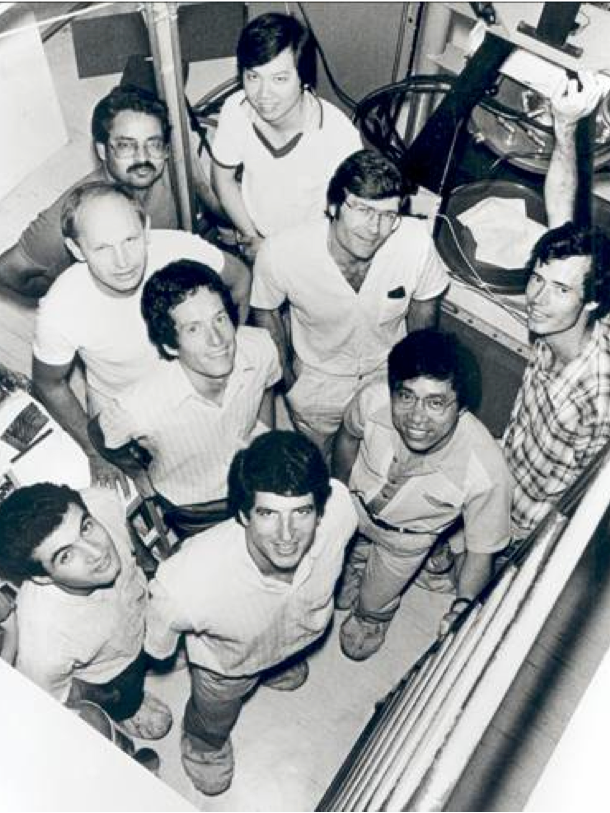 A black-and-white photo of a group of smiling men in shirt sleeves.