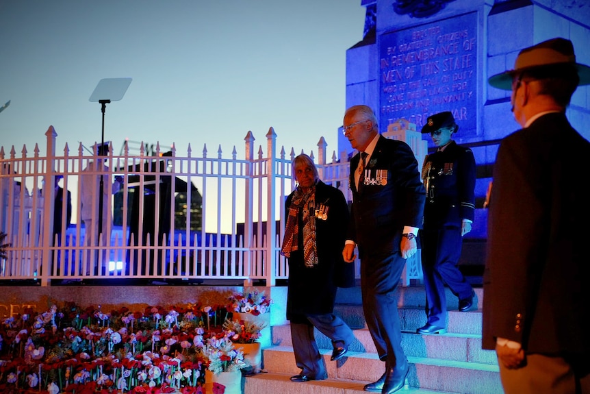 Two people walk down off a stage