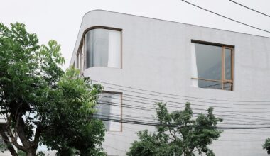 oom house’s curved concrete volumes interlock through glass hinge